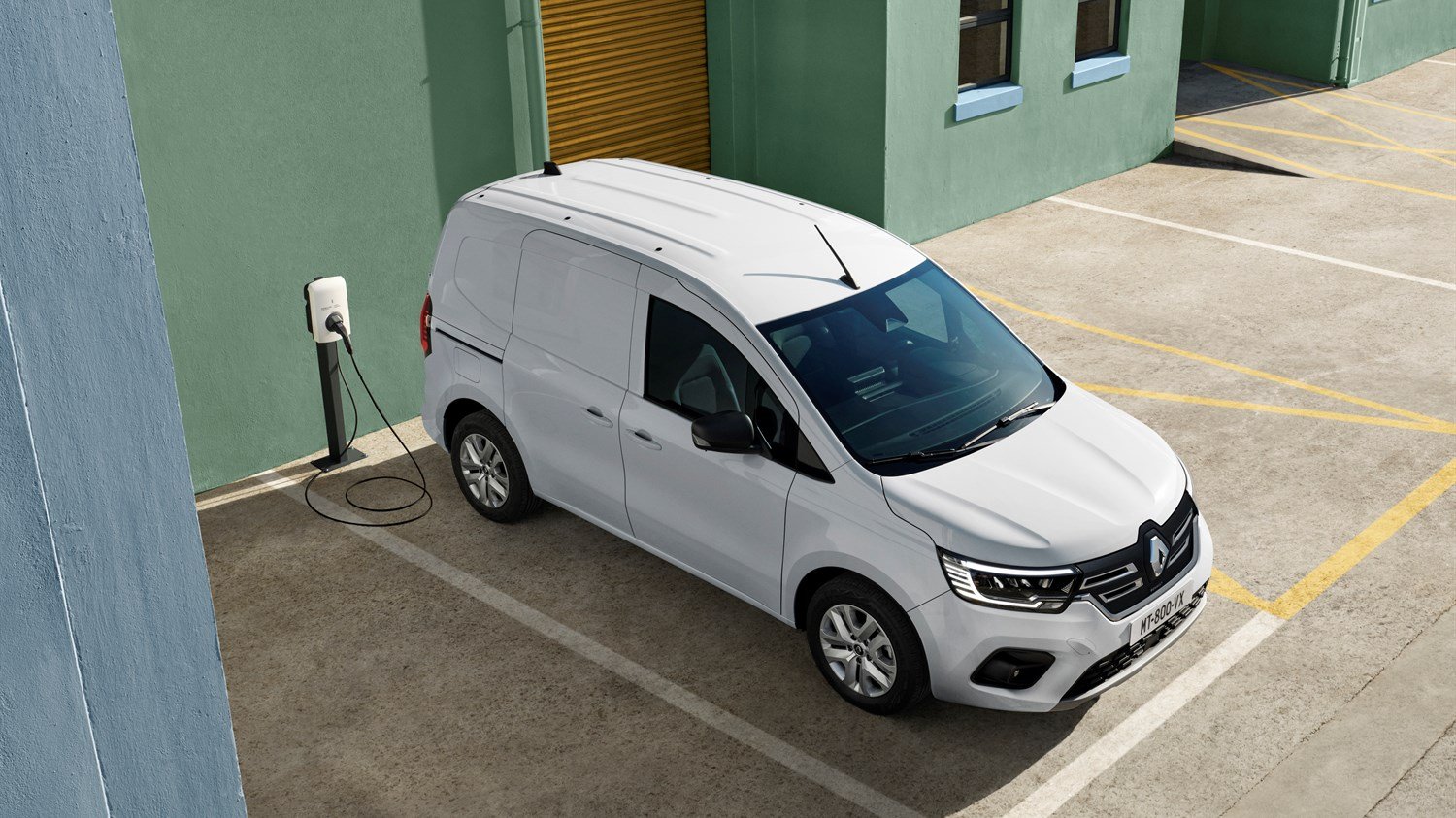 A Renault Kangoo E-Tech parked outside a contemporary building, highlighting its innovative features and stylish appearance.